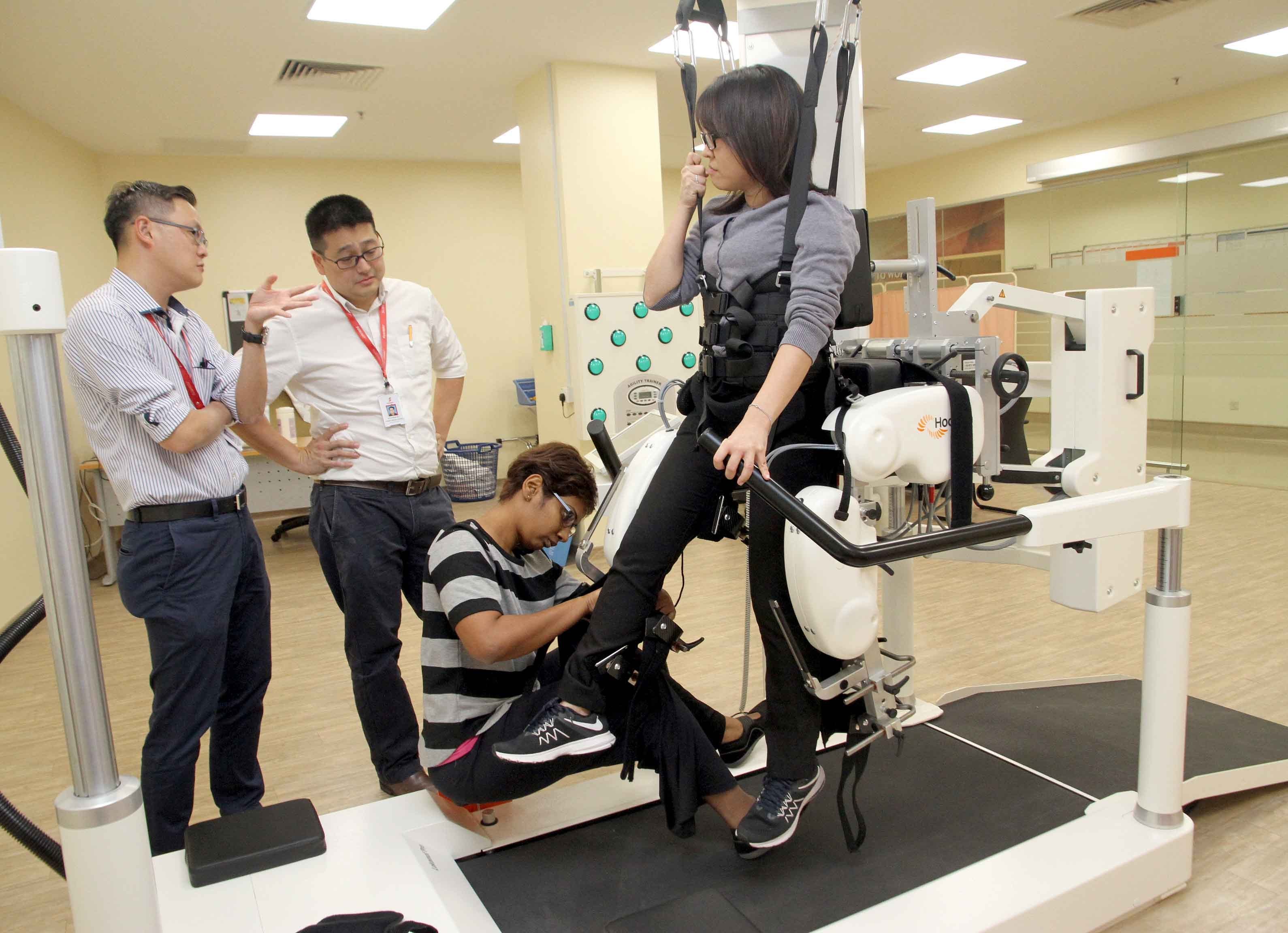物理治疗师示范如何贴上感应器，让机器装置帮助患者复健。
